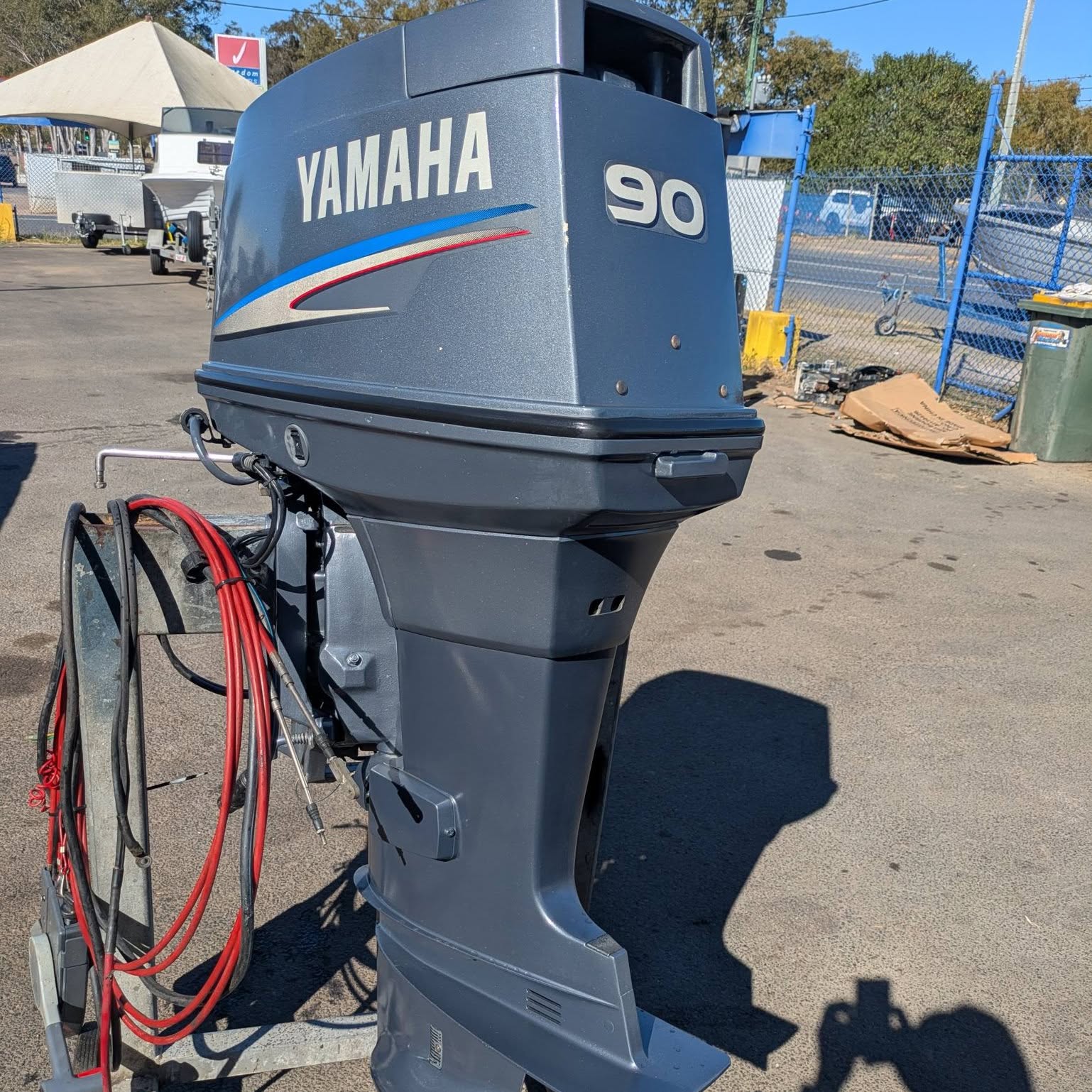 A Yamaha 90 two stroke outboard standing in the yard